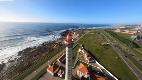 órbita fpv loca y buceo de construcción alrededor del faro volando bajo sobre la costa rocosa