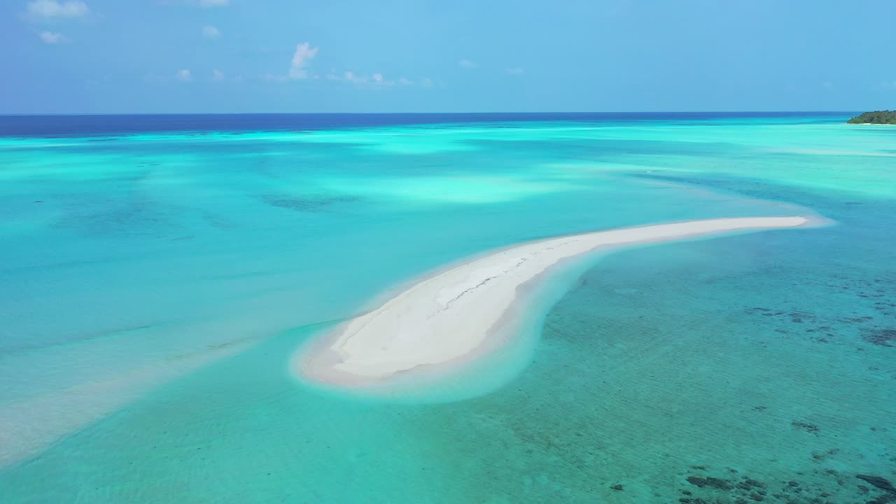 Isola paradisiaca di sabbia in un mare blu cristallino vista dal cielo, perfetta per il riposo e il divertimento alle Maldive