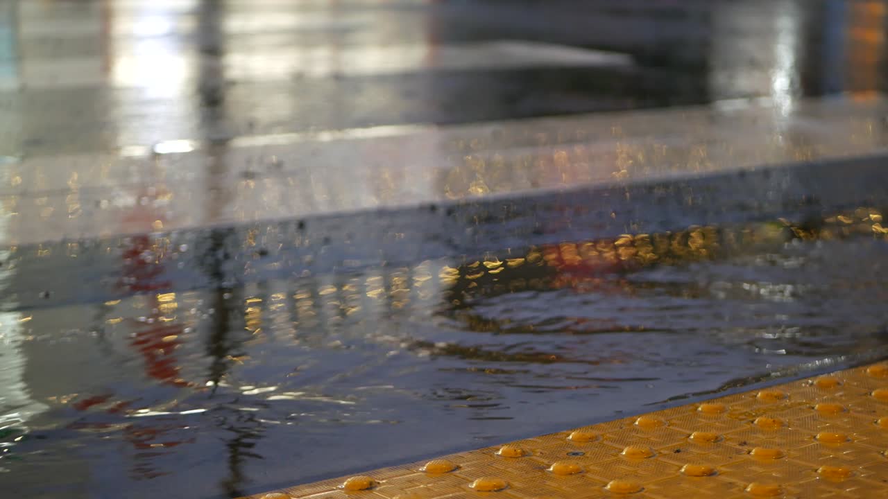 Gotas de chuva em asfalto molhado de rua urbana nos EUA, com reflexos