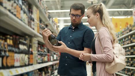 couple shopping for beer and wine in a grocery store