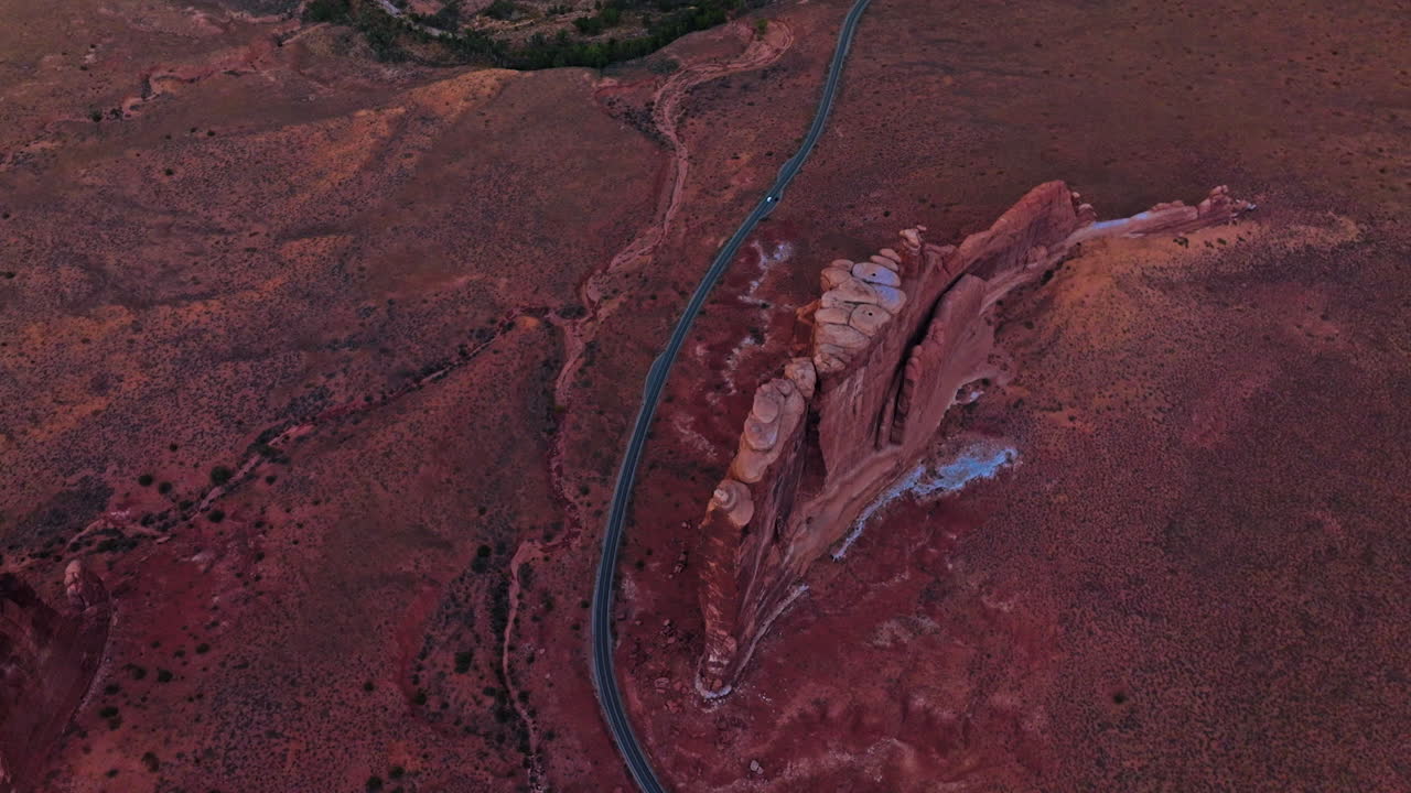 Long speed road going through a wild dessert landscape. Drone flying high above the plain in Zion canyon, Utah, USA.