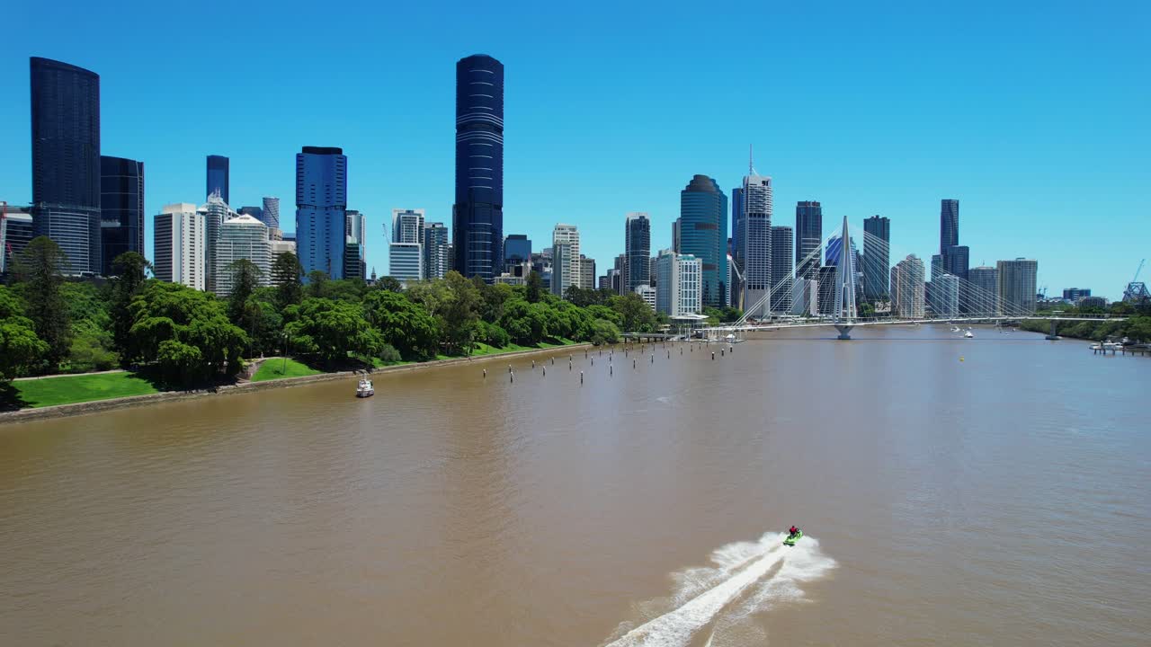 Cityscape of Brisbane with jet ski on river, seen from Kangaroo Point cliffs