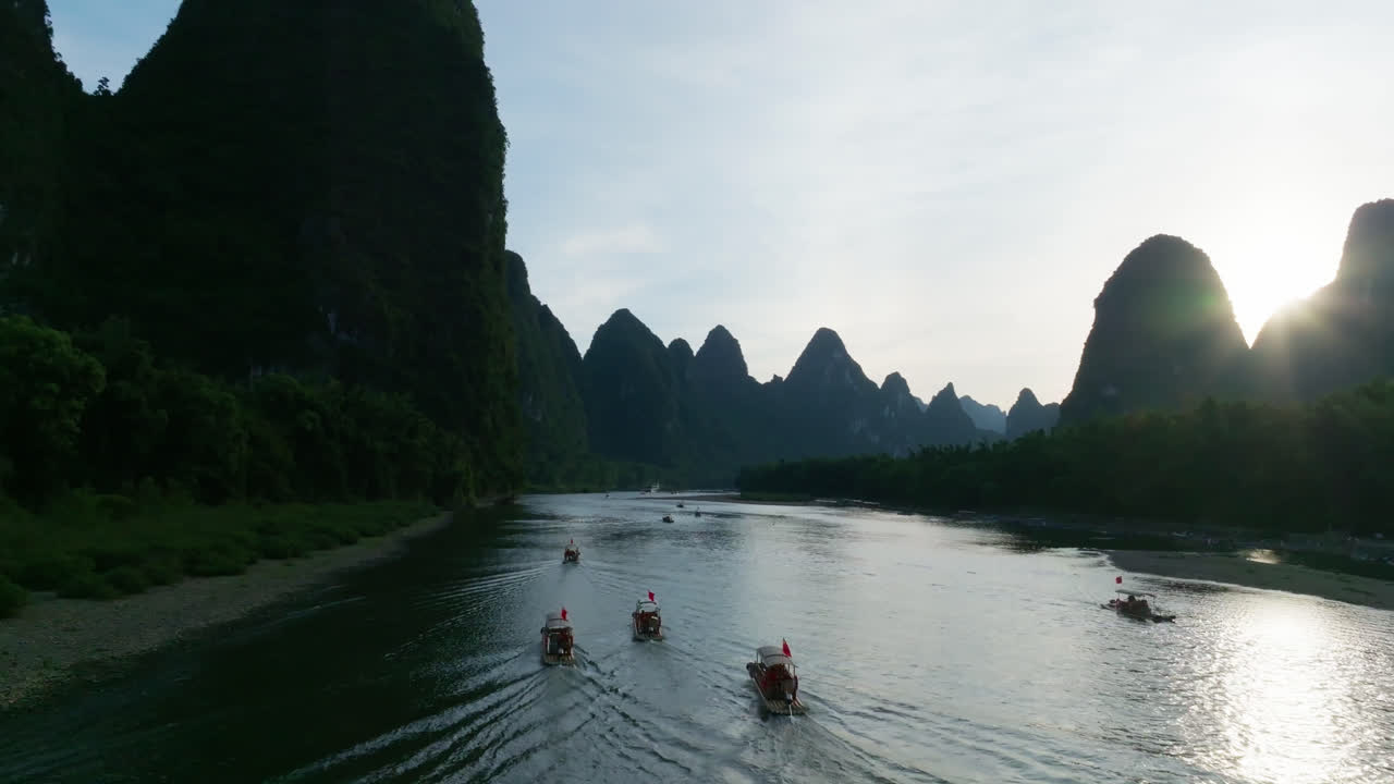 Aerial view tilting over bamboo rafts on the Li river, sunset in Yangshuo, China