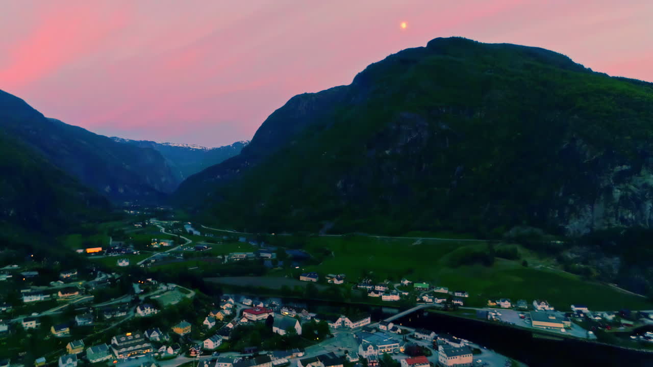 вид с воздуха на норвежскую деревню в аурланде во время пурпурного заката за горами