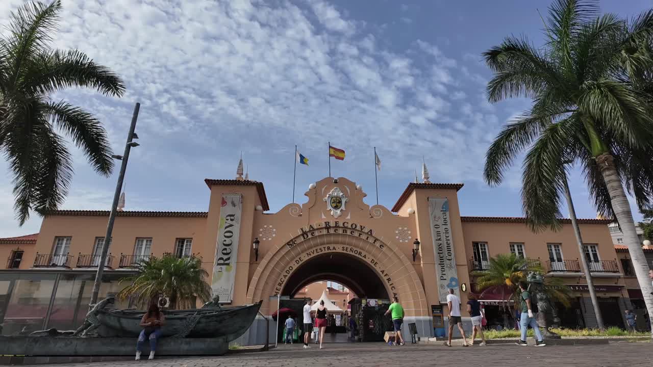 Timelapse of the historical colonial market of Santa Cruz de Tenerife, La Recova, with a changing sky with few clouds and people coming and going. 4K