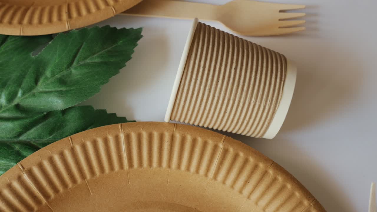 platos de vidrio eco y tenedor en una planta verde de fondo blanco. salvemos el medio ambiente. 4k
