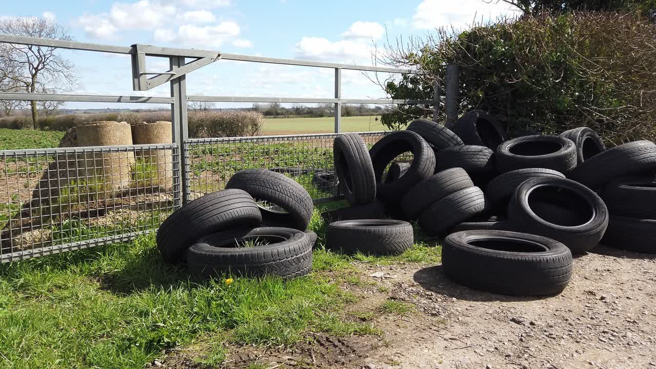 A load of tyers dumped in a gateway on a rural road in England United Kingdom. Criminal activity of fly tipping.