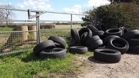 a load of tyers dumped in a gateway on a rural road in england united kingdom. criminal activity of fly tipping.