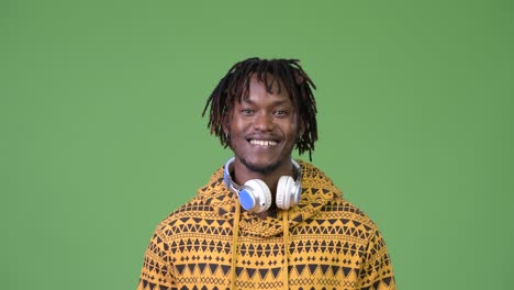 young happy handsome african man smiling while wearing headphones