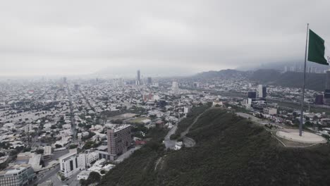disparo de drones en un día nublado por la mañana en hasta bandera sobre el cerro obispado en la ciudad de monterrey, méxico-12