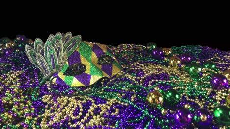 sparkling colorful carnival mask on pile of mardi gras beads