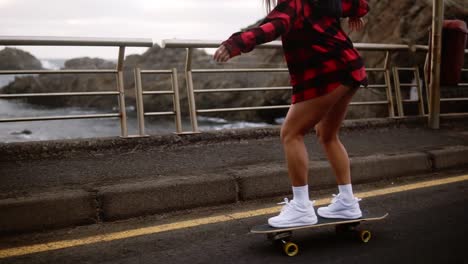 Young-Pretty-Beautiful-Brunette-Hipster-Woman-In-Plaid-Coat-Having-Fun-Riding-Skateboard-Longboard-Downhill-On-Beautiful-Road-In-Slow-Motion-1