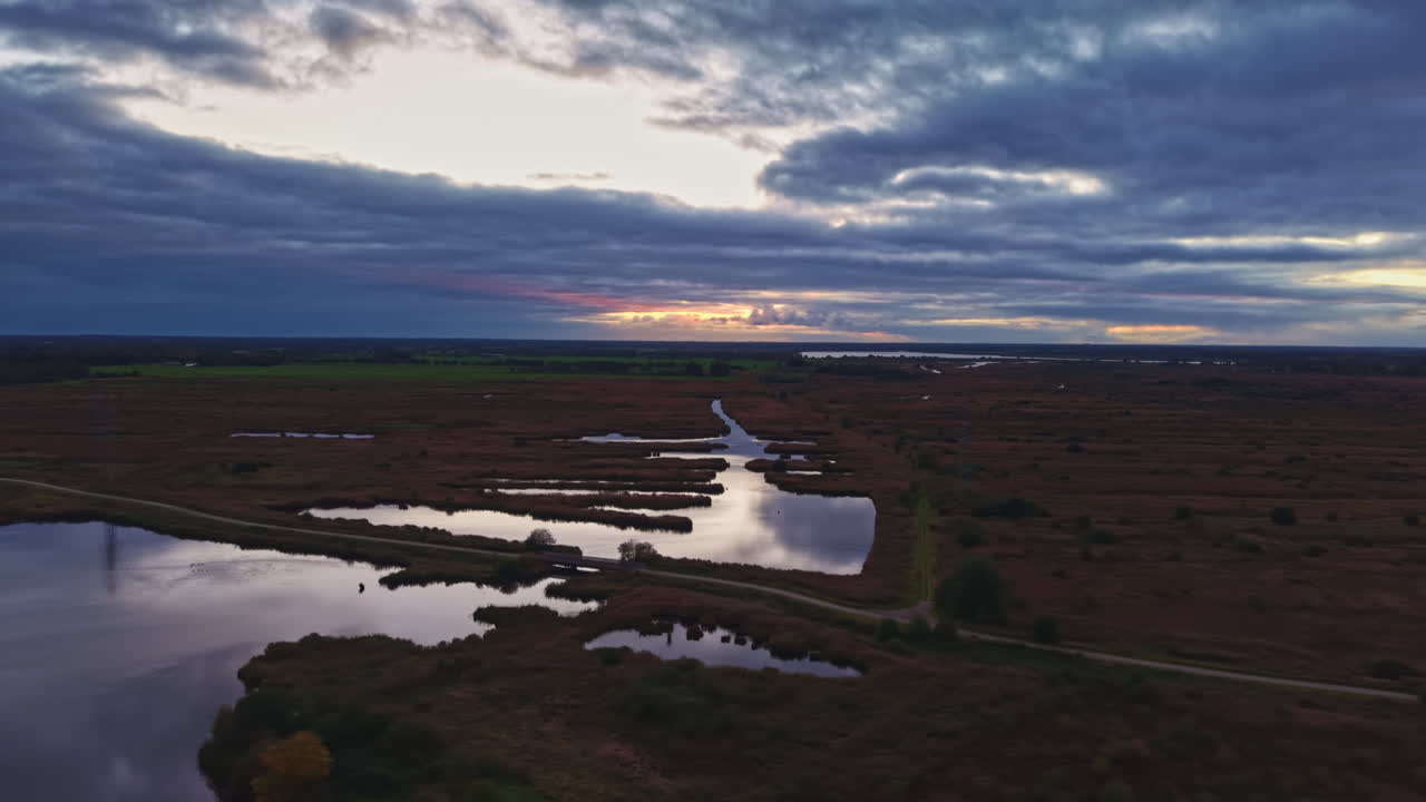 La luce del mattino illumina le tranquille zone umide, riflettendo cieli sereni e tortuose vie d'acqua in uno splendido paesaggio naturale.
