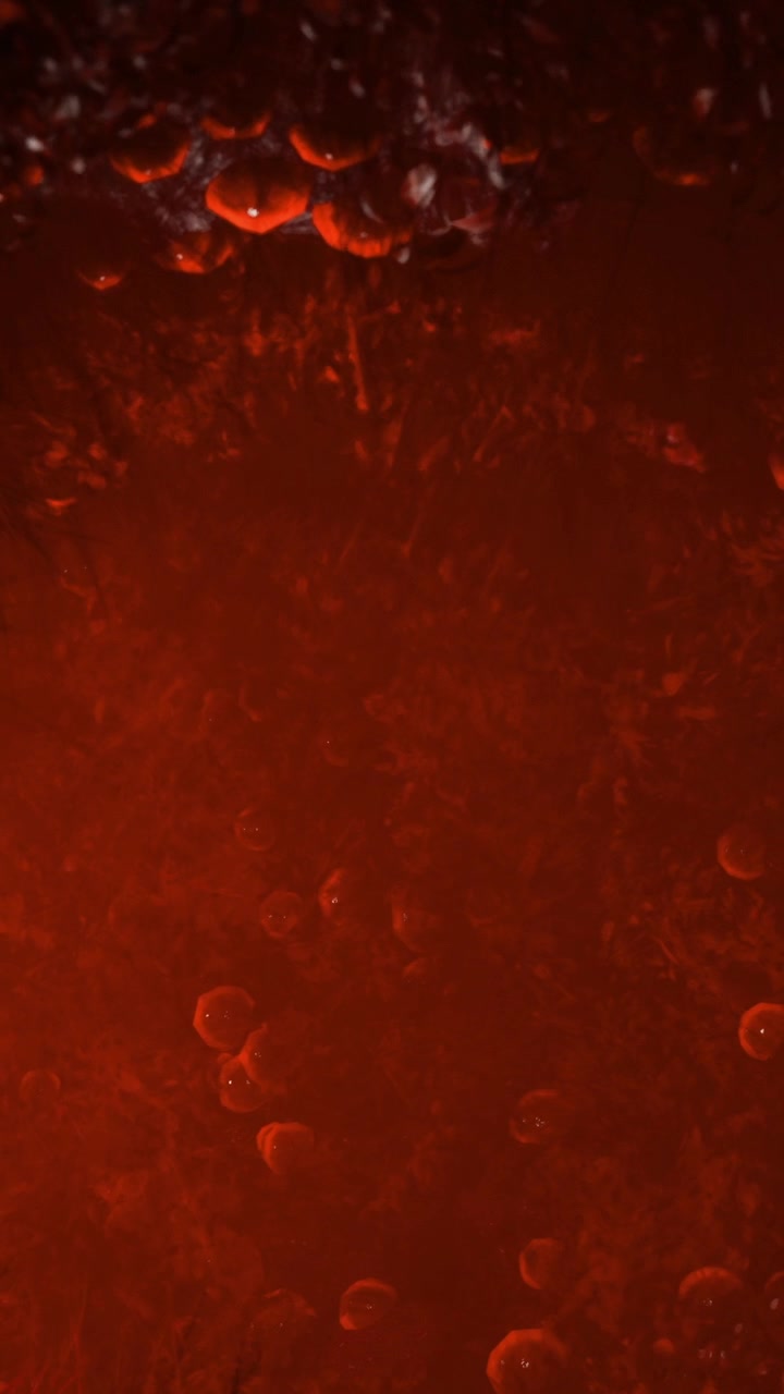 Liquido con bolle e colori caldi su uno sfondo scuro.