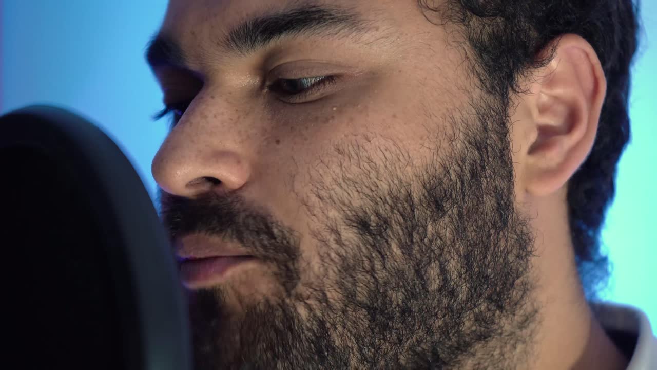 primer plano de músico cantando suavemente frente al micrófono