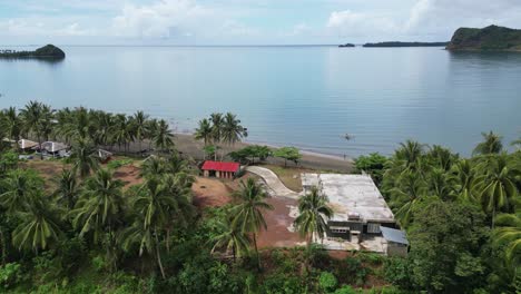 simple fishing village with wooden huts, aerial forward establisher, open sea