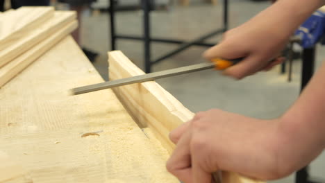 student using a rasping tool in woodwork classroom, close up