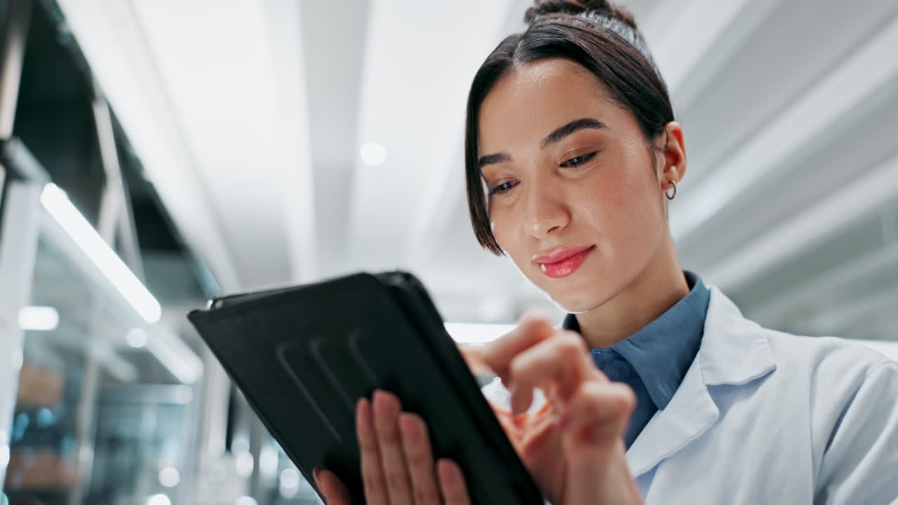 un médico sonriente usando una tableta en un hospital