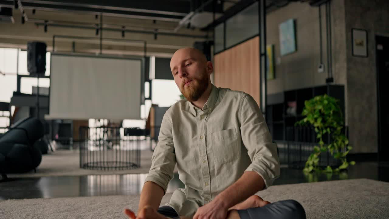 Man Stretching and Meditating in a Modern Office