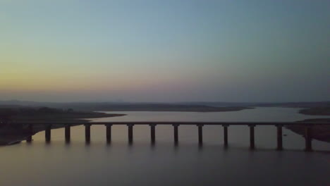 down to top shot of bridge joining lands on either side of lake in hyderabad, india during sunset