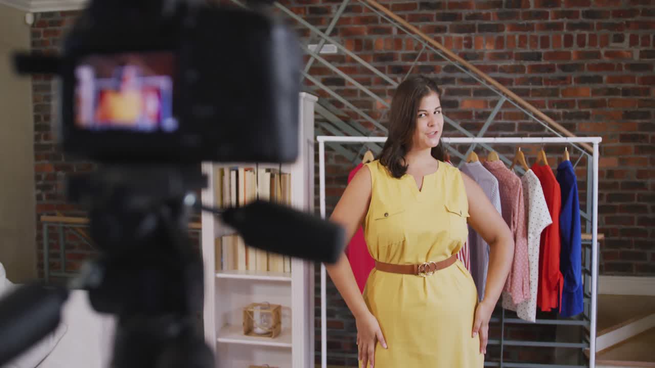 Una vlogger donna caucasica che realizza un video di moda a casa.