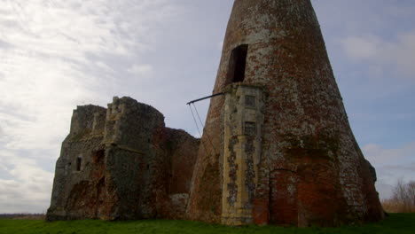 tilting wide shot of st benet’s abbey 16th century gatehouse with 18th century windmill