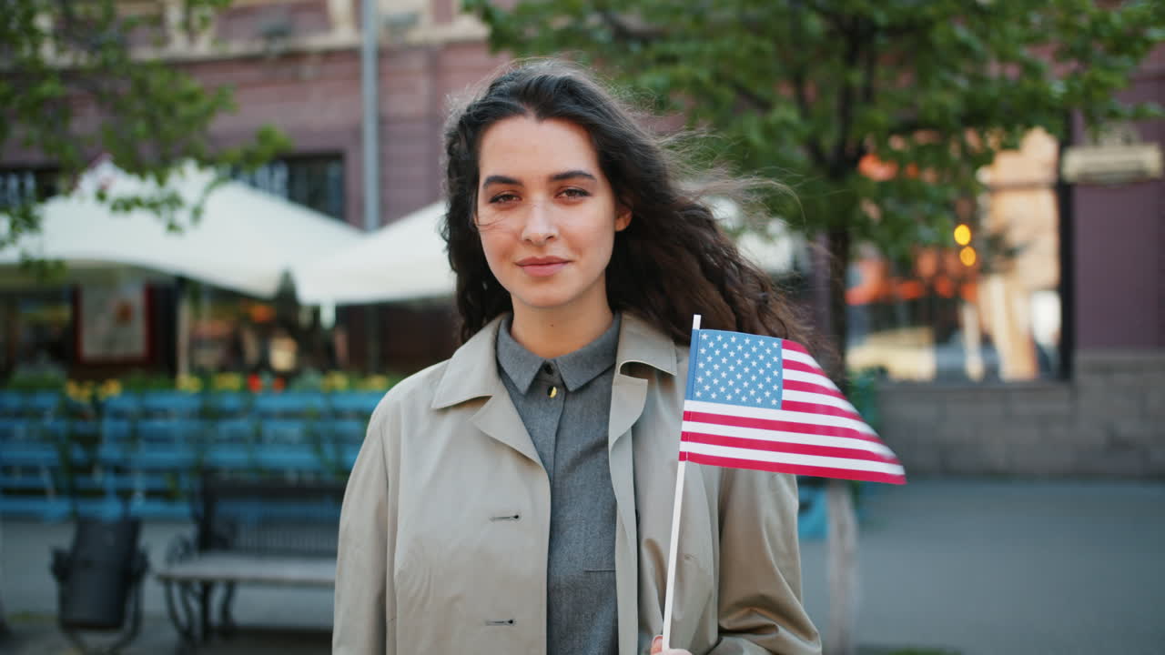 Young woman holding American flag in city street