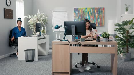 pranks, jokes in the company, girls sitting in the office in front of computers, bored with work start throwing paper airplanes at each other, laughing, having fun, loosening up