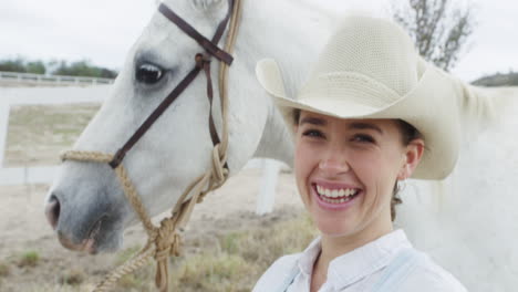 smiling cowgirl with white horse