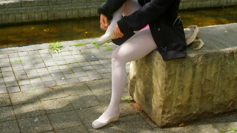 Low-section-of-female-ballerina-wearing-ballet-shoe-in-the-park-4k