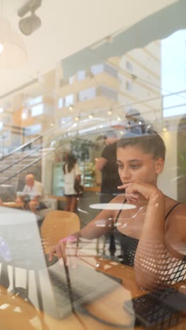 woman working on laptop in a cafe