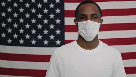 video estático de un hombre con máscara facial en la bandera estadounidense