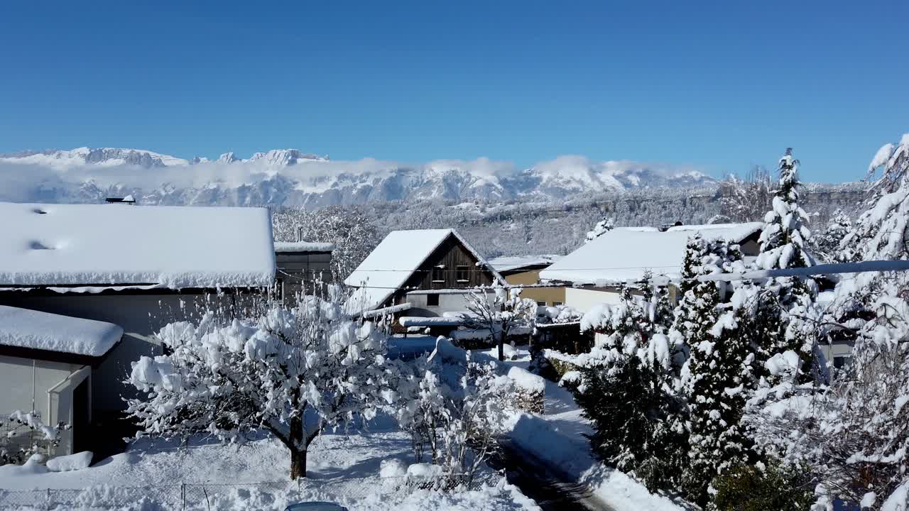 알프스 산과 푸른 하늘과 눈으로 가득 찬 집들의 영상