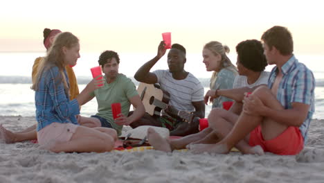 Un-Grupo-Diverso-De-Amigos-Disfruta-De-Una-Reunión-En-La-Playa-En-Una-Fiesta.