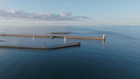 two sail boats entering northumberland harbour on calm summer evening