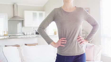 Caucasian-woman-wearing-gray-blouse-with-arms-on-waist