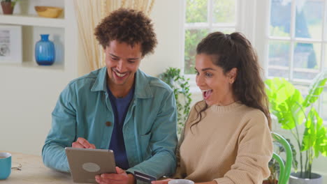 couple with credit card at home use digital tablet to review finances for starting business