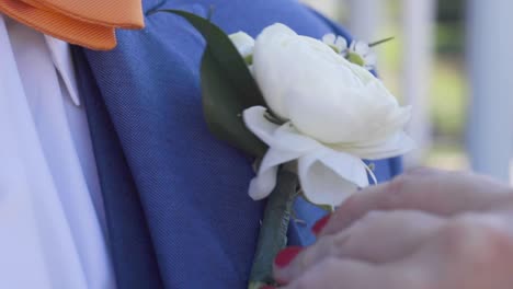 groom getting flowers pinned before ceremony