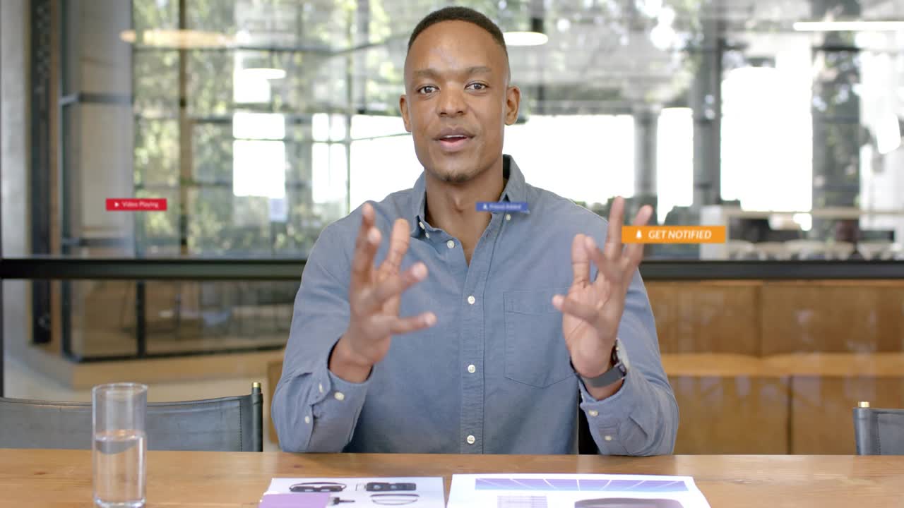Male speaker speaking in office, UI play icons multiplying around him, showing marketing demo