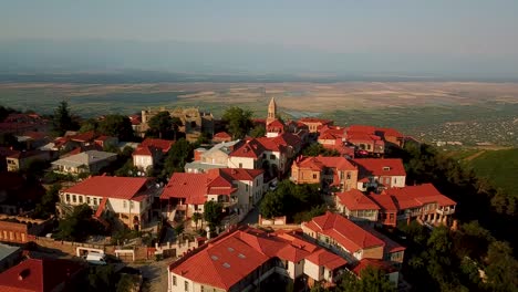 city of lovers couple sighnaghi in georgia in caucasus with white house and brown rooftops, cobbled pavements and luxury lodges in a peaceful scenic travel destination beautiful highland landscape