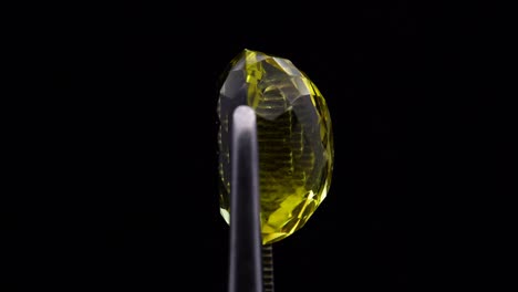 natural yellow citrine in the tweezer on the turning table