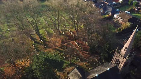 Slow-pan-down-shot-above-English-church-steeple---cemetery