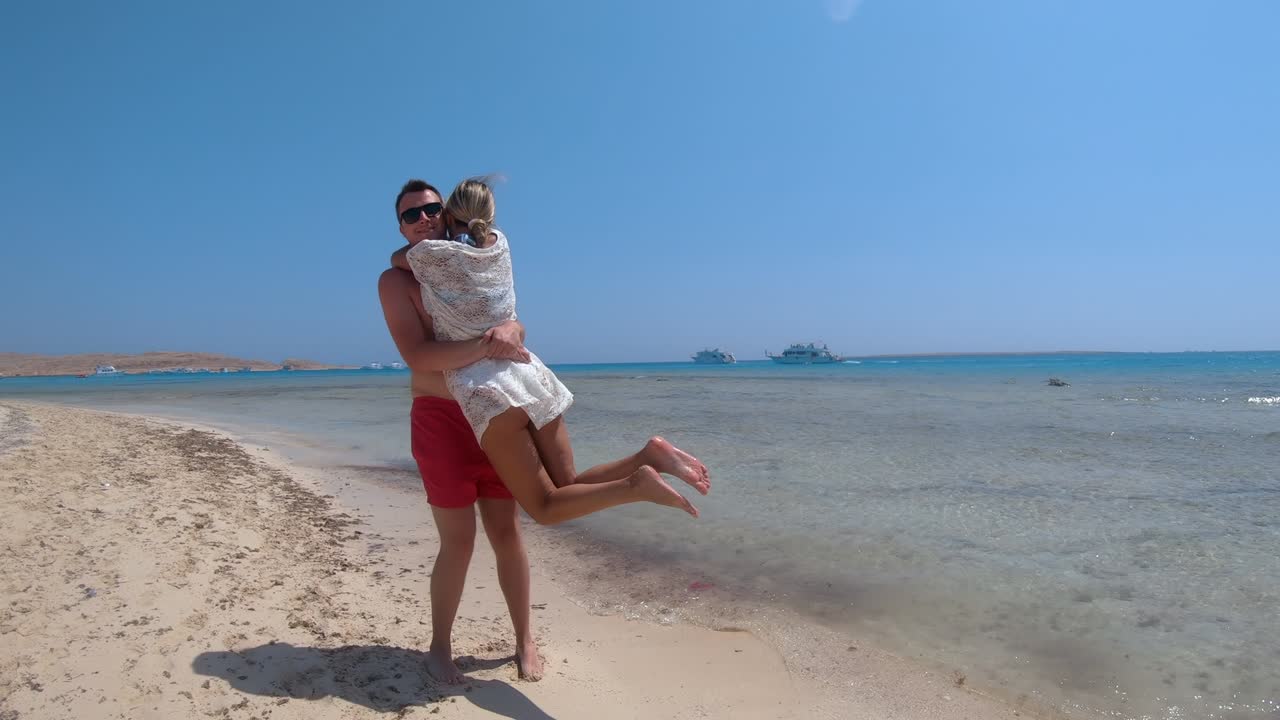 Happy couple turning round on tropical paradise beach, super slow motion