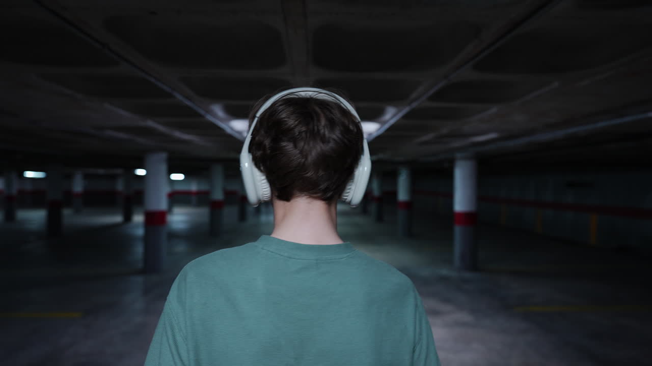Person with Headphones in an Empty Underground Parking Garage