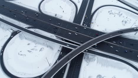 Vista-Aérea-De-Una-Intersección-De-Autopistas-Cubierta-De-Nieve-En-Invierno.