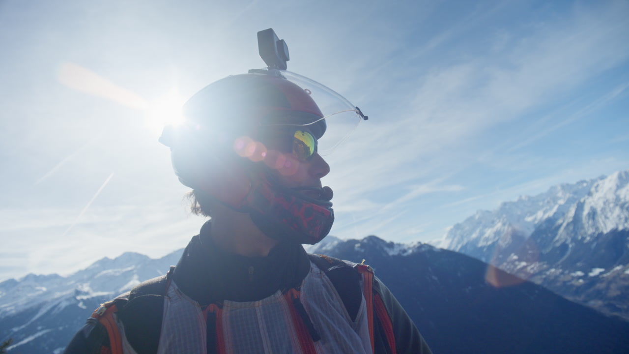 Wingsuit BASE jumper flying over Verbier surrounded by alpine mountains with snow-covered peaks. High-speed flight, dramatic scenery, and cinematic extreme sports action in the Swiss Alps.