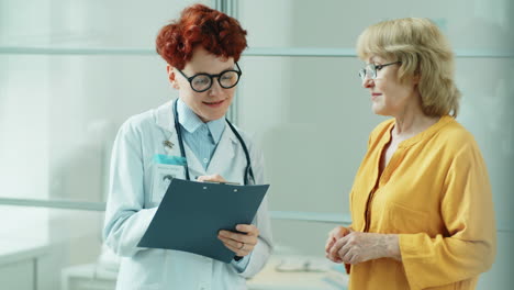 mujer mayor hablando con una doctora en la clínica