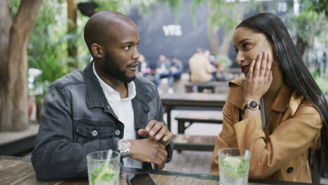 a young couple chatting and having cocktails