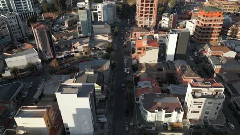drone aéreo inclinado hacia arriba disparado sobre las carreteras a ambos lados de los edificios de la ciudad en la paz, bolivia en un día soleado