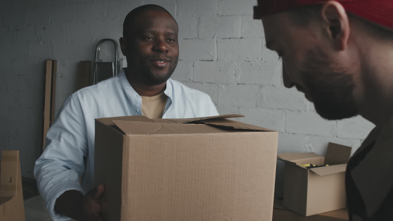 People Carrying a Cardboard Box